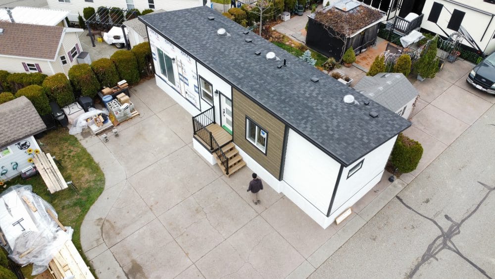 Aerial exterior view of a completed modular home with entry steps and driveway