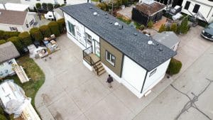 Aerial exterior view of a completed modular home with entry steps and driveway